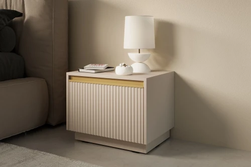 Beżowy stolik nocny Resto z szufladą i złotymi akcentami stojący