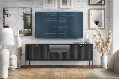 Szafka RTV Nuo czarna z ryflowanymi drzwiczkami i szufladą z czarnymi nogami